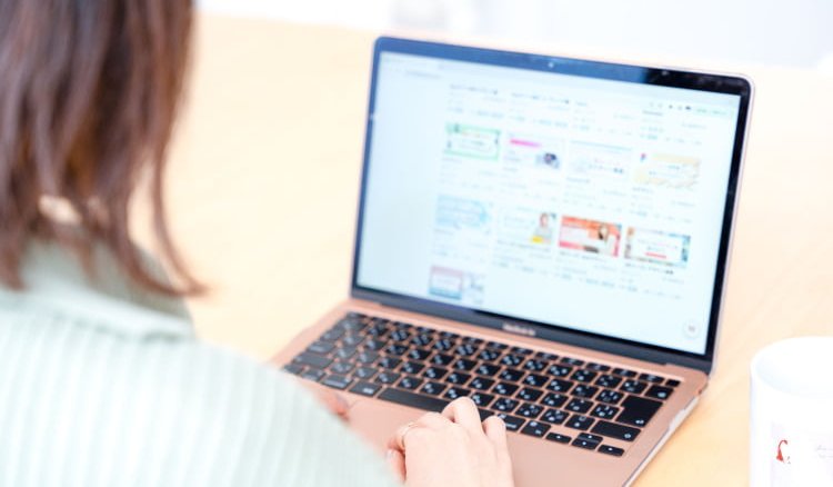 ノートPCの画面を見ながら作業するゆきさん（後ろ姿）