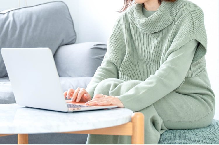 ノートPCで作業するゆきさん（後ろ姿、リビングのソファ横）