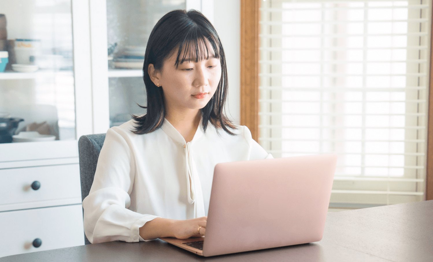 白ブラウス姿でノートPCを見つめ入力する千晴さん