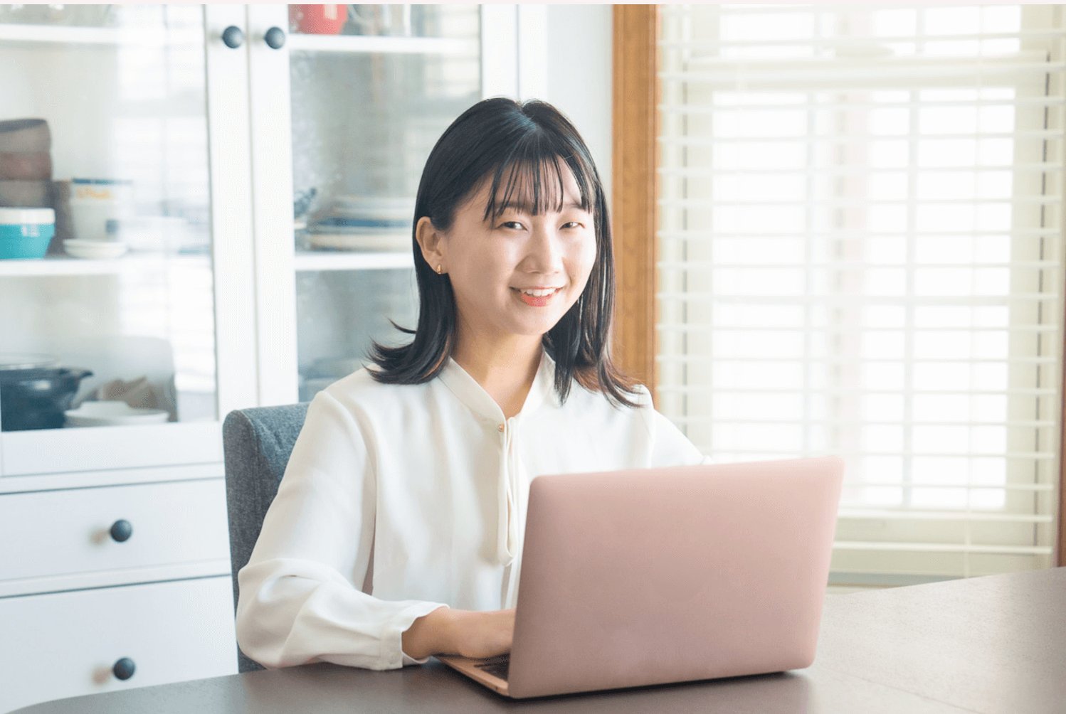 白ブラウス姿で微笑みながらノートPCを操作する千晴さん