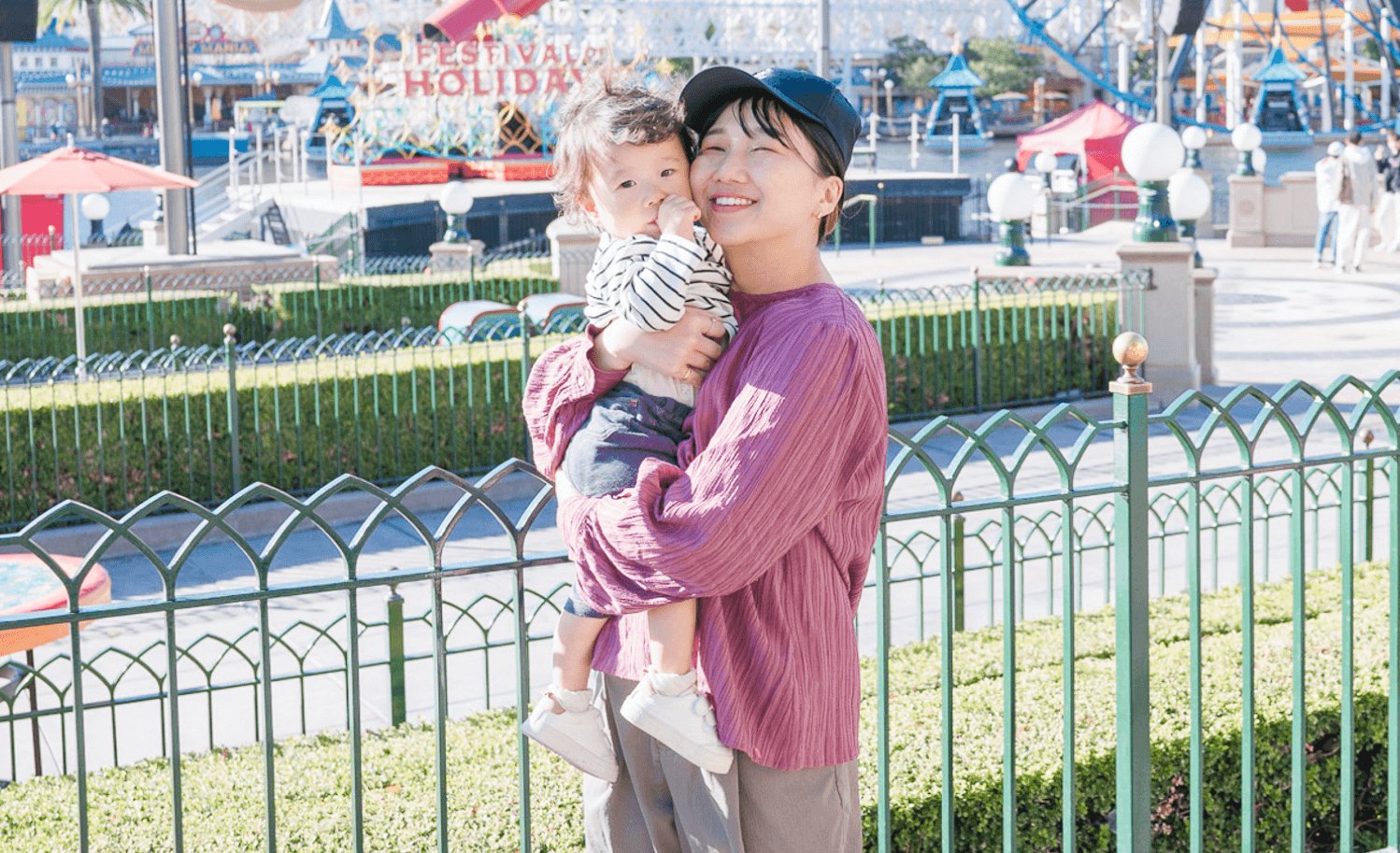 遊園地で我が子を抱っこして微笑む千晴さん