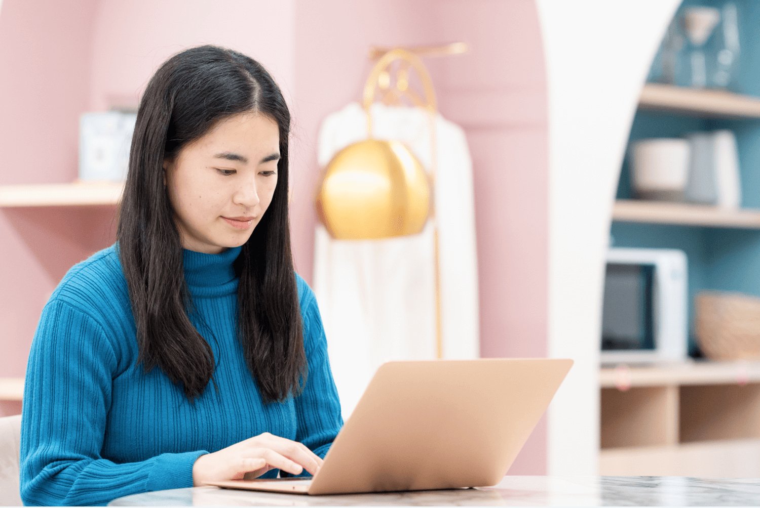 ピンク・ブルーの棚を背に、ノートPCを操作するぺっぱーさん