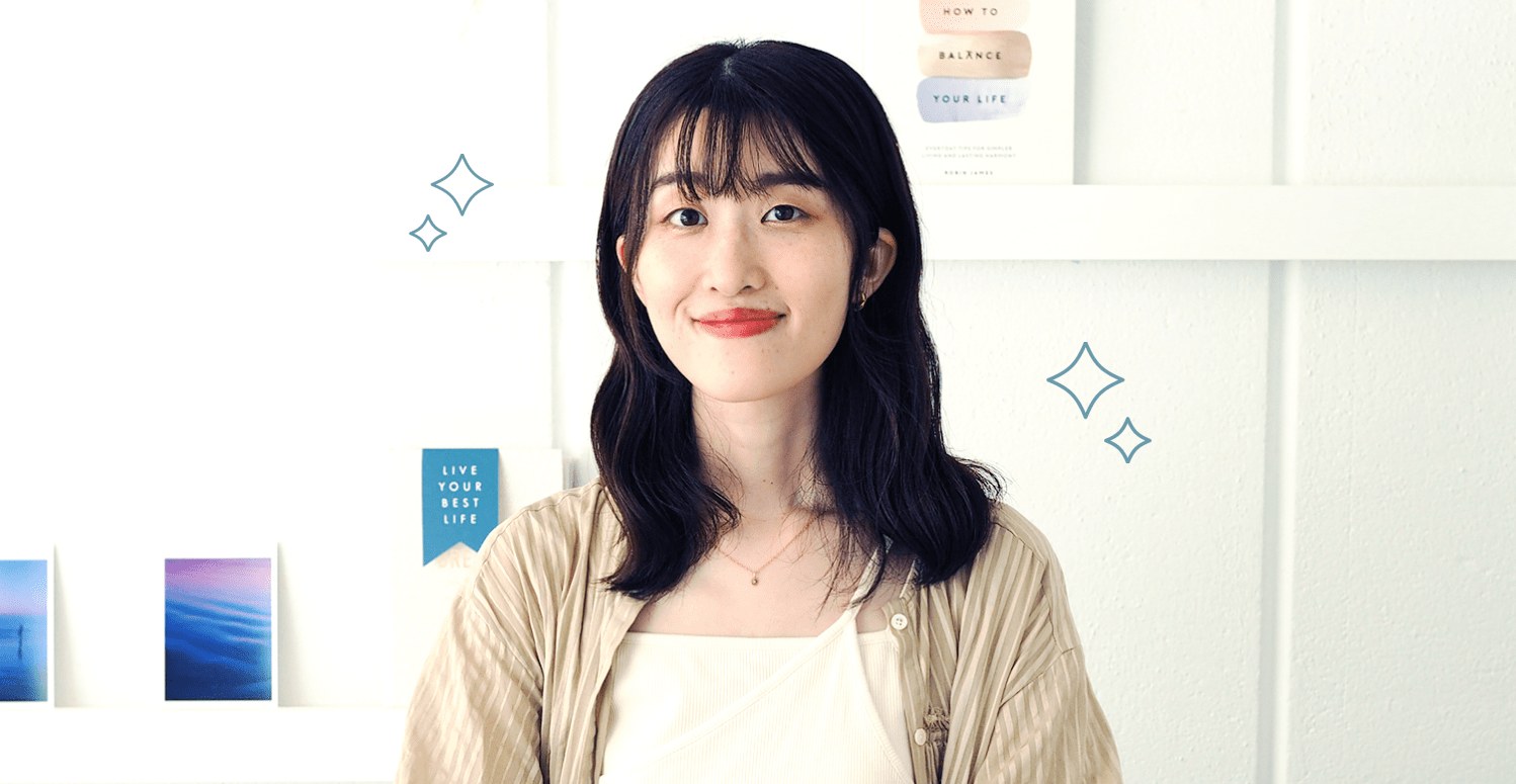 フォトフレームが並ぶ棚の前に立つかえさんの写真