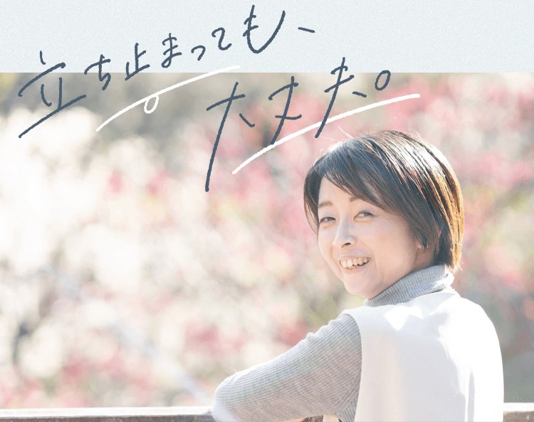 「立ち止まっても、大丈夫。」という手書き文字が添えられた、振り返って微笑むあやこあにぃさんの写真