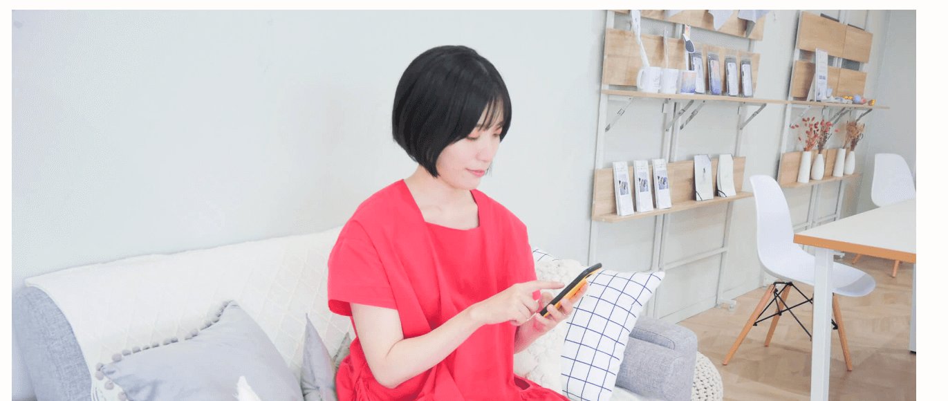 ソファに座りスマホを操作するあっこさんの写真