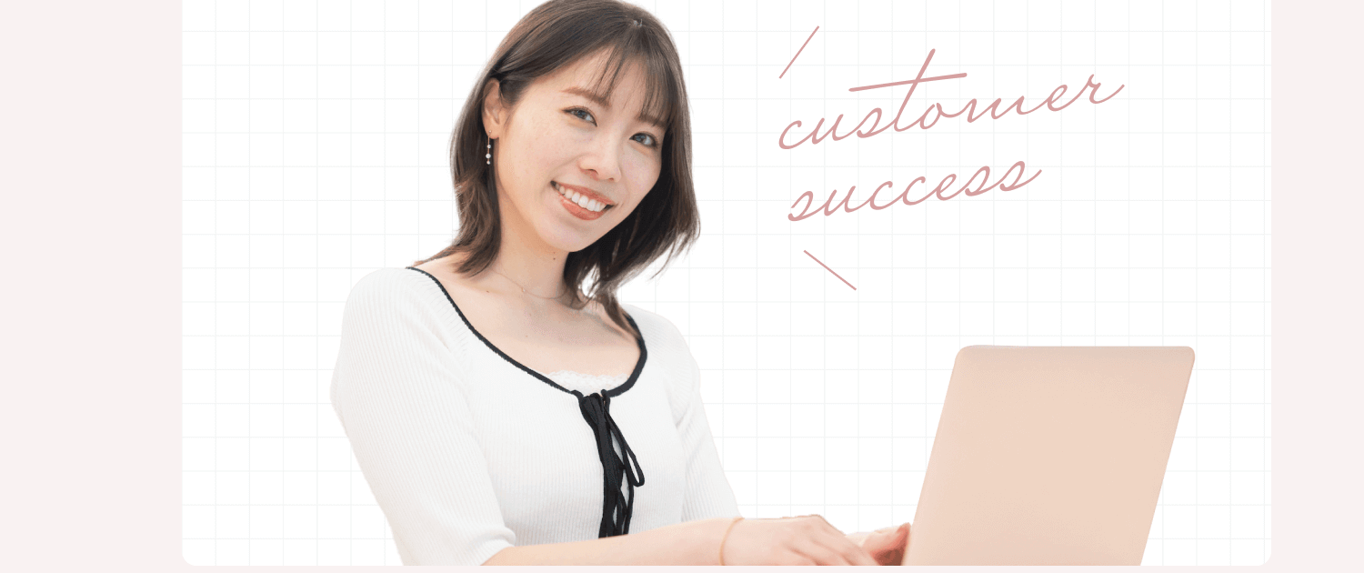 ノートPCを操作しながら微笑むめぐみさん。手書き風の「customer success」の文字が添えられている