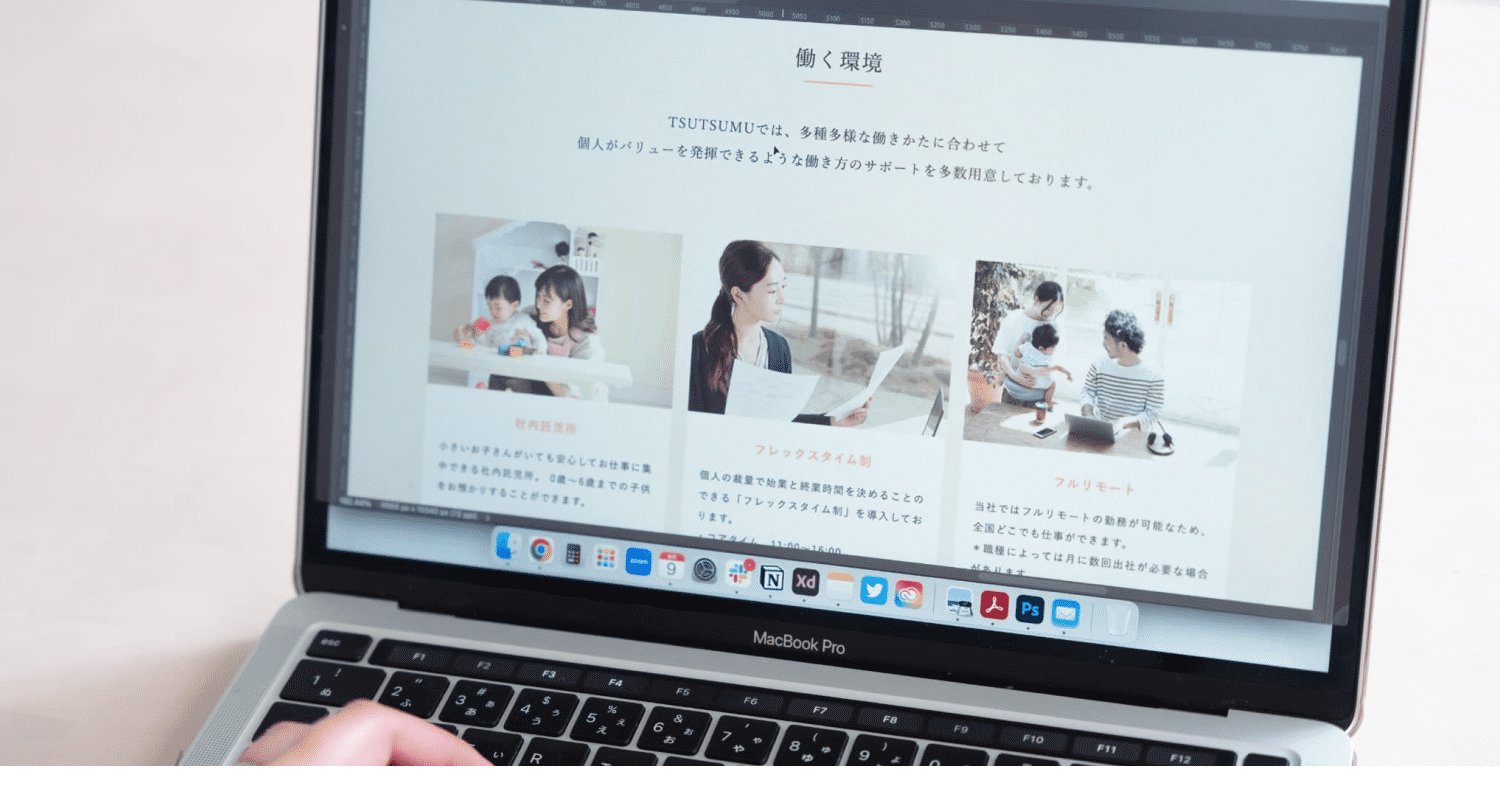 ノートPCの画面に映る「働く環境」ページ(社内託児所・フレックスタイム制・フルリモートの3枚の写真付き紹介)を指差す手元