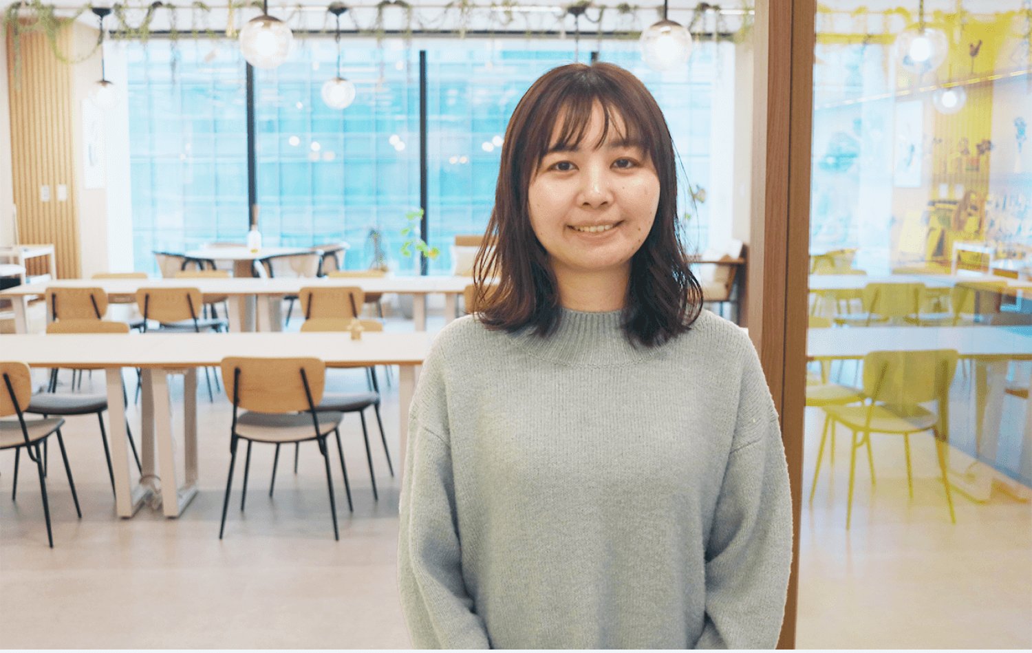 コワーキングスペースの入り口に立つSAKIさんの正面バストアップ