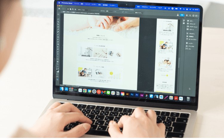 ノートPCでPhotoshopを開き、ポートフォリオ制作物を編集する手元の写真