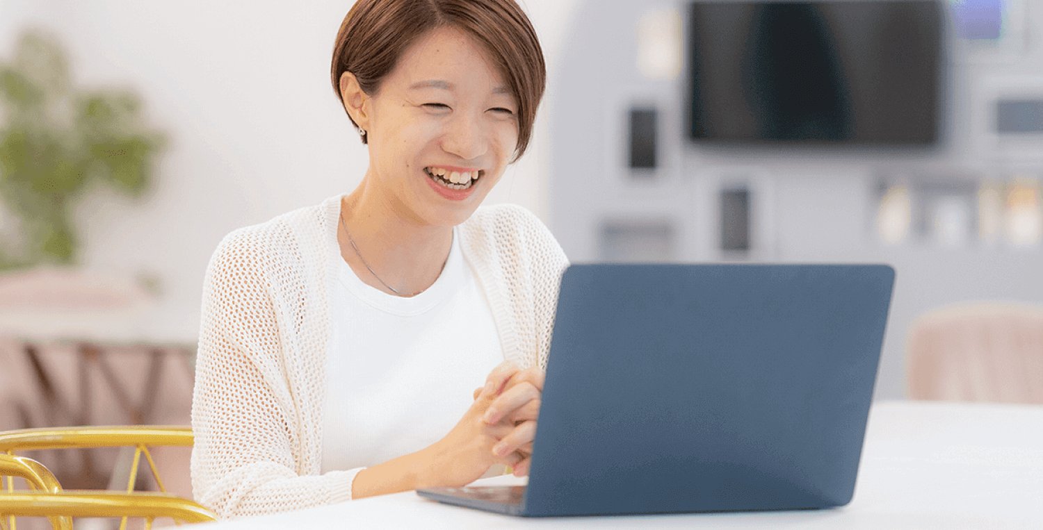 カフェ風の部屋でノートPCに向かい笑顔を見せるちっひーさん