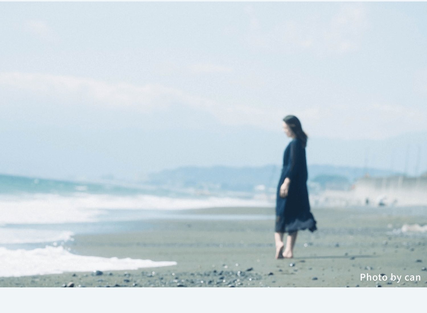 海辺を歩くのぞみさんの後ろ姿