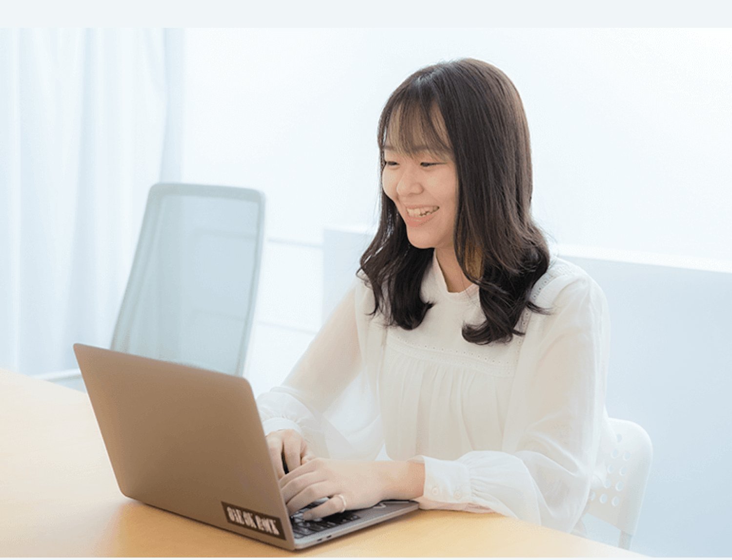 自宅のデスクで笑顔でノートPCを操作するなこてんさん