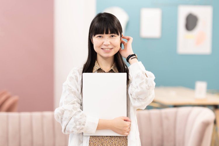白いノートPCを抱え、耳に手を添えて微笑むちゃみさん