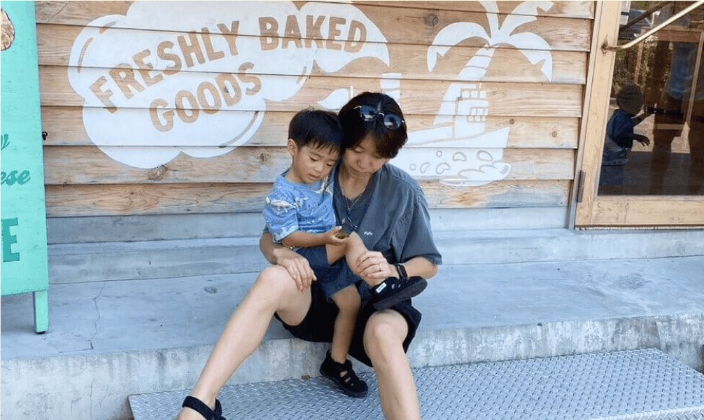 パン屋の店先で息子を膝に乗せて座るちっひーさん