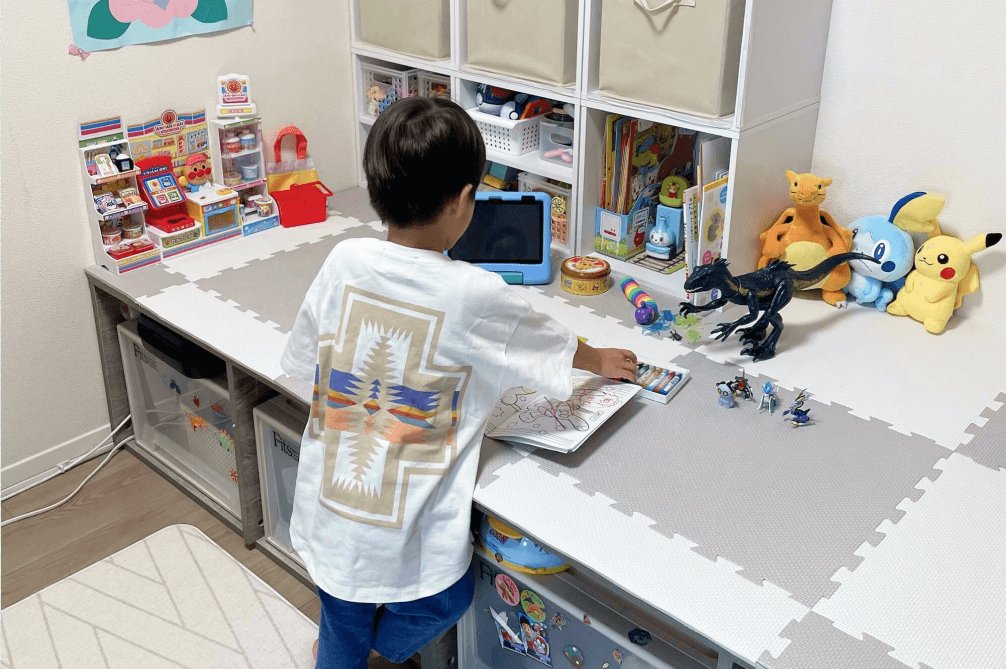 リビングの学習コーナーで塗り絵をする息子の後ろ姿