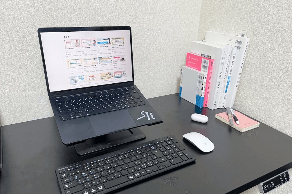 スタンド付きノートPCとキーボード・マウスが置かれた作業デスク