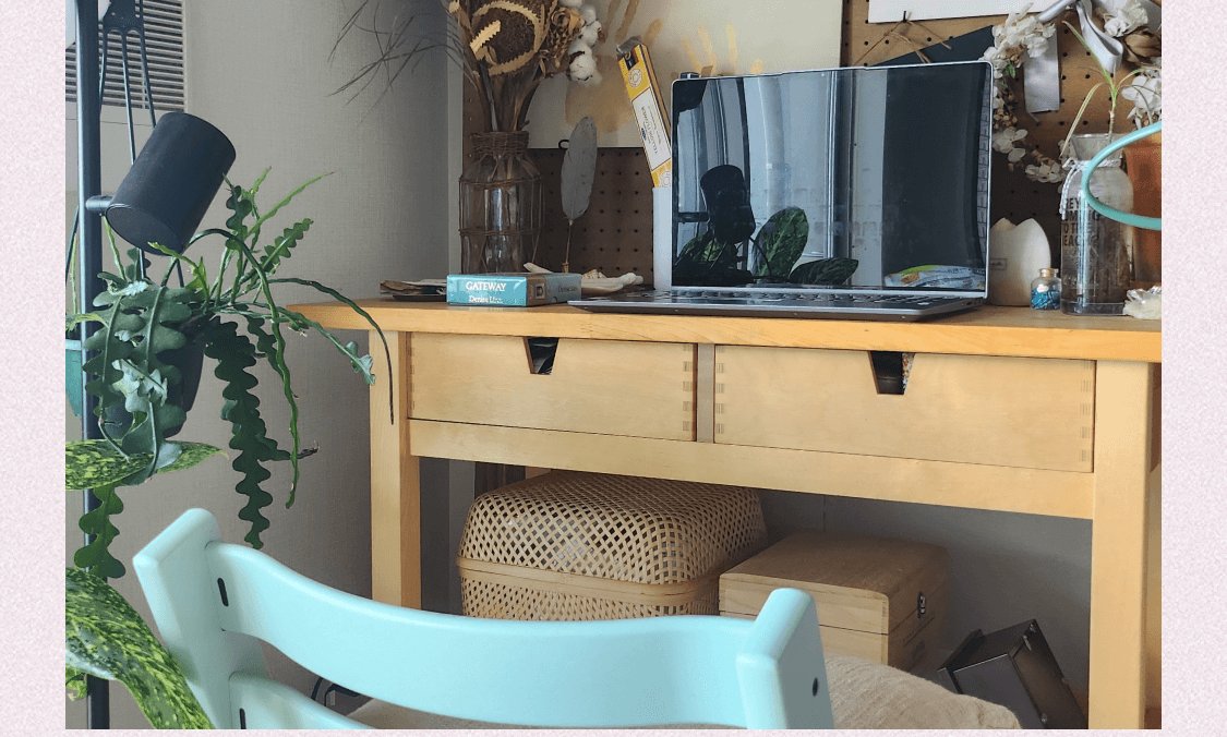 観葉植物とノートPC、ドライフラワーが置かれた木製デスクと水色のチェア