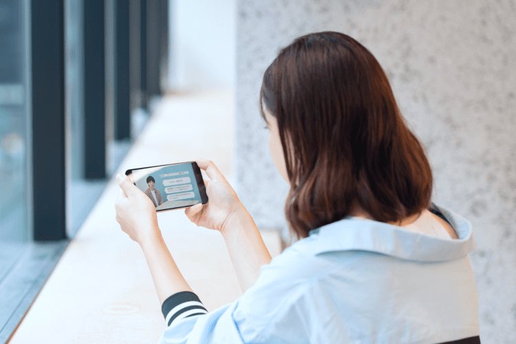 スマートフォンを見る璃奈さんの後ろ姿