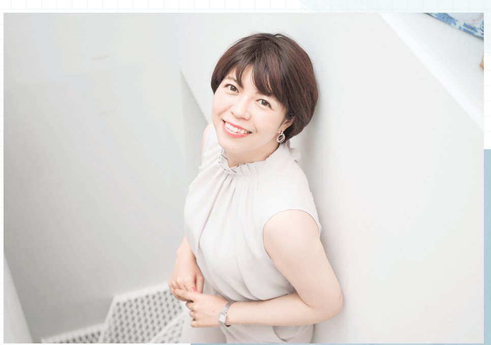 壁にもたれて微笑む利穂さん