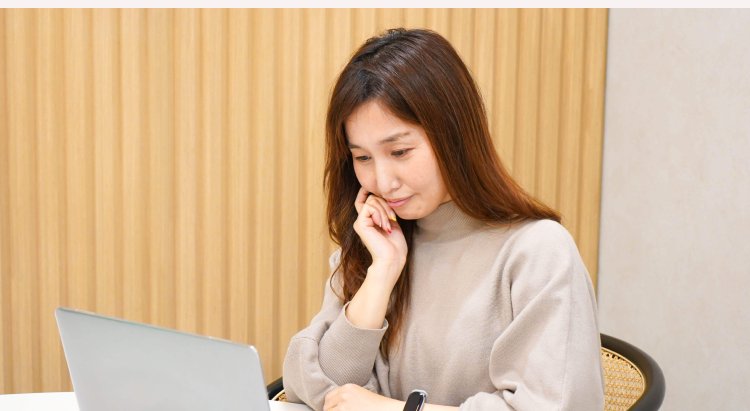 ノートPCの画面を見ながら考え込む表情ののんさん