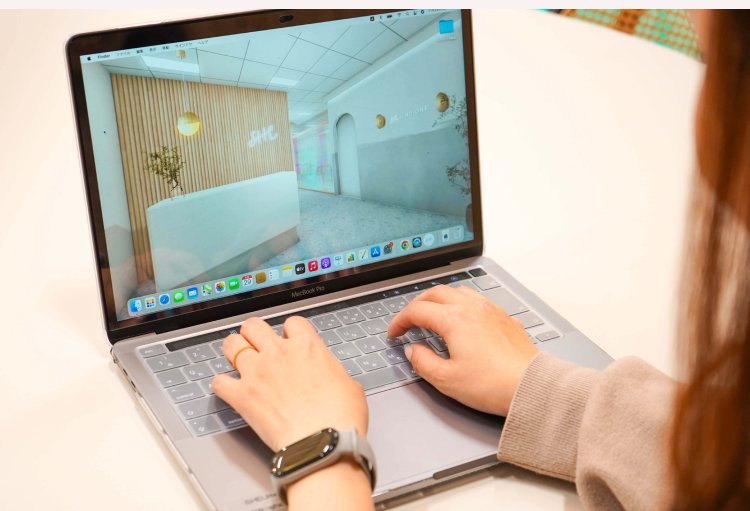 ノートPCの画面に映る店舗内装の3Dパースを操作するのんさんの手元