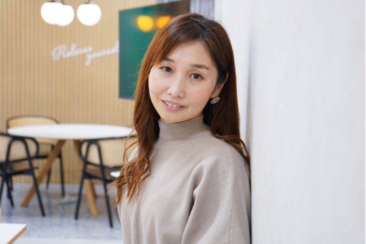 カフェ風の室内で微笑むのんさんのポートレート
