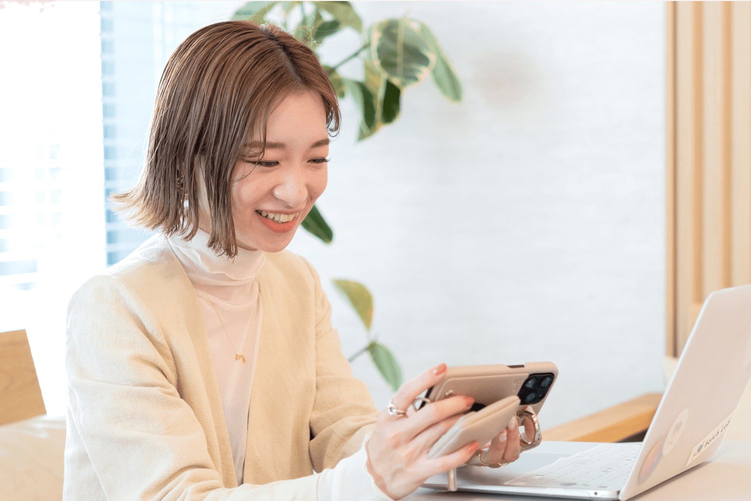 スマートフォンを操作しながら微笑むJURIさん