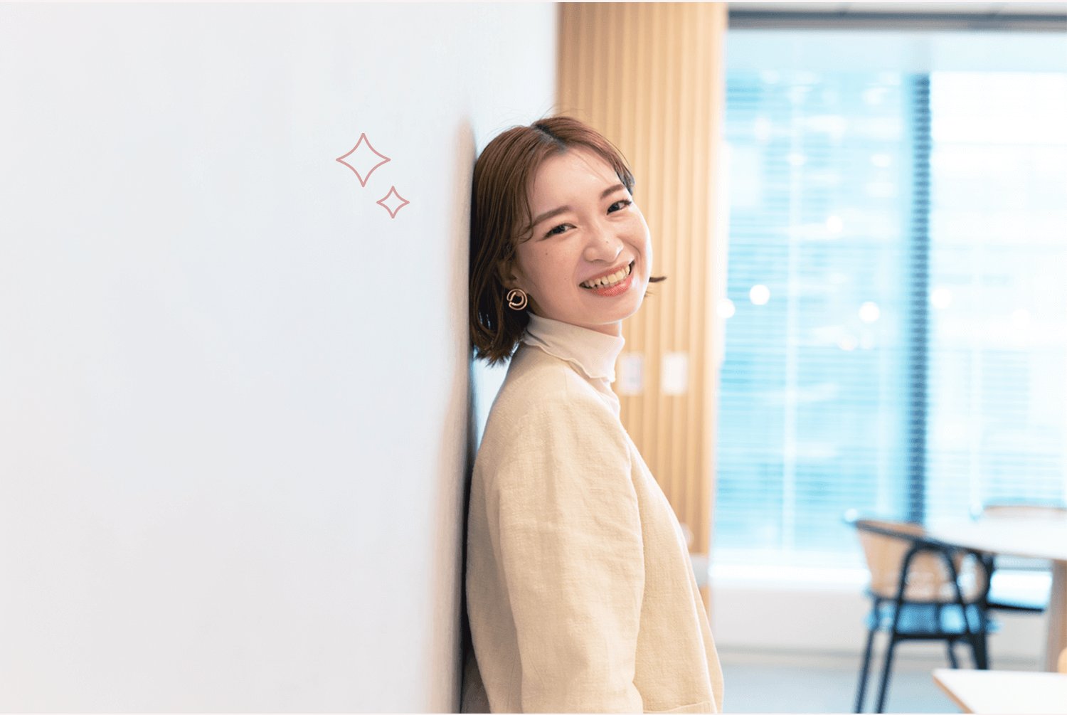 壁に寄りかかり振り返って微笑むJURIさん