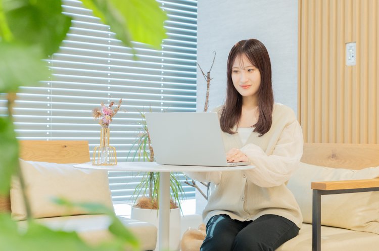 ラウンジ席でノートPCを操作するmeguさん