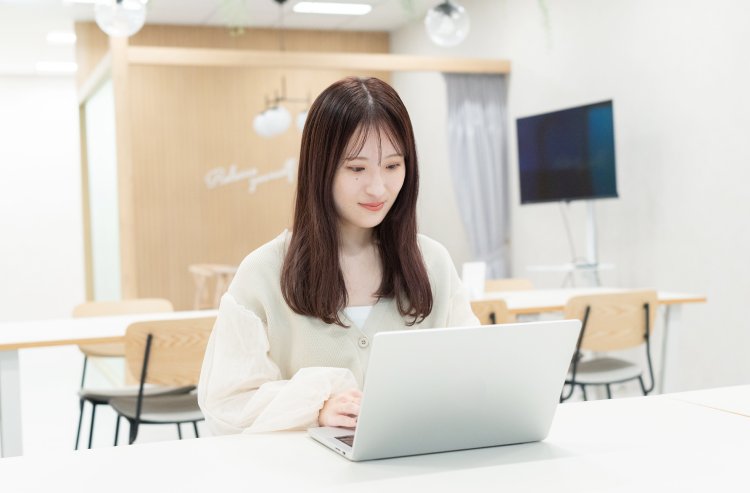 オフィスのカウンター席でノートPCを操作するmeguさん