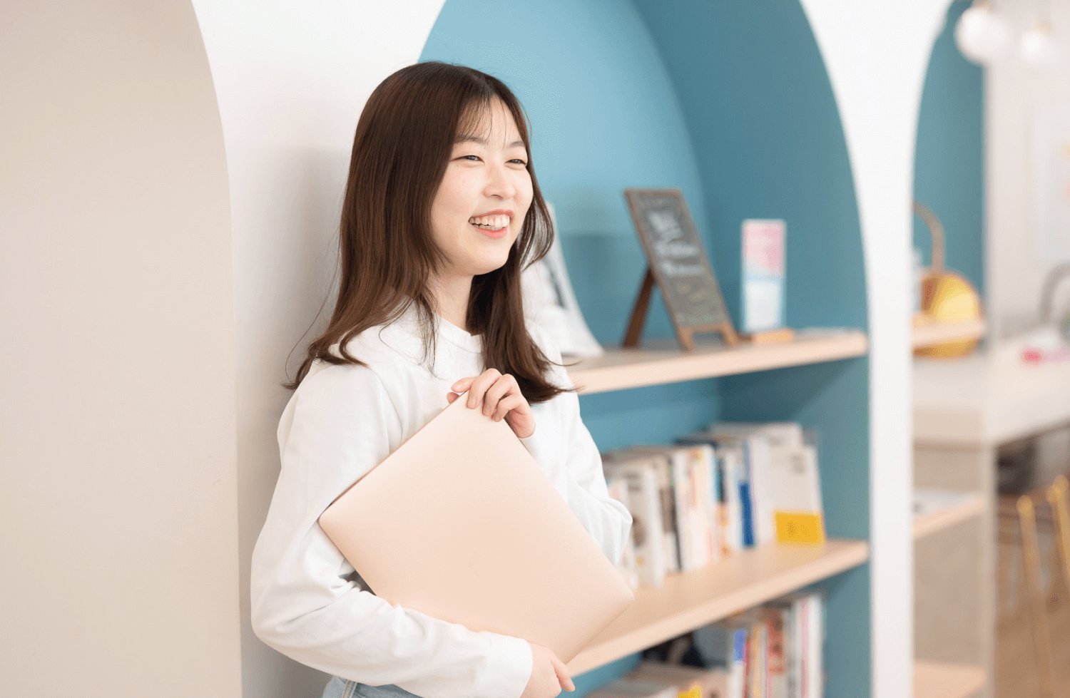 青いアーチ型の内装を背景に微笑むおはぎさん