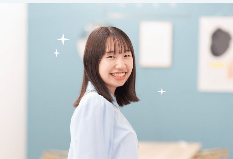 壁掛けフレームの前で横向きに微笑むHicaさん