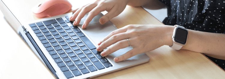 ノートPCのキーボードを操作する愛さんの手元