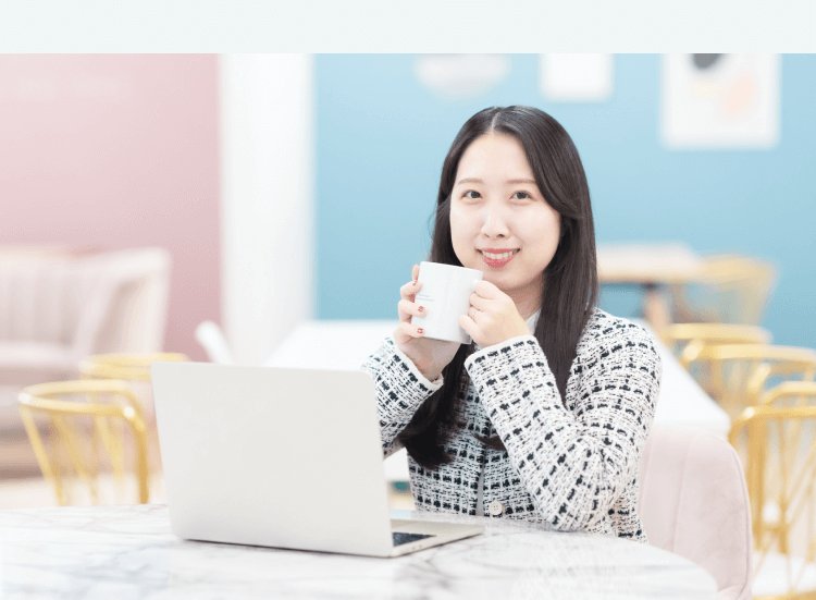 マーブル調テーブルでコーヒーマグを持ちながらノートPCに向かうかんなさん