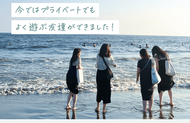 夕方の海辺で波打ち際に立つ4人の女性の後ろ姿の写真。「今ではプライベートでもよく遊ぶ友達ができました！」の文字が添えられている
