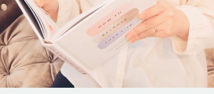 ソファに座り本「HOW TO BALANCE YOUR LIFE」を読む手元の写真