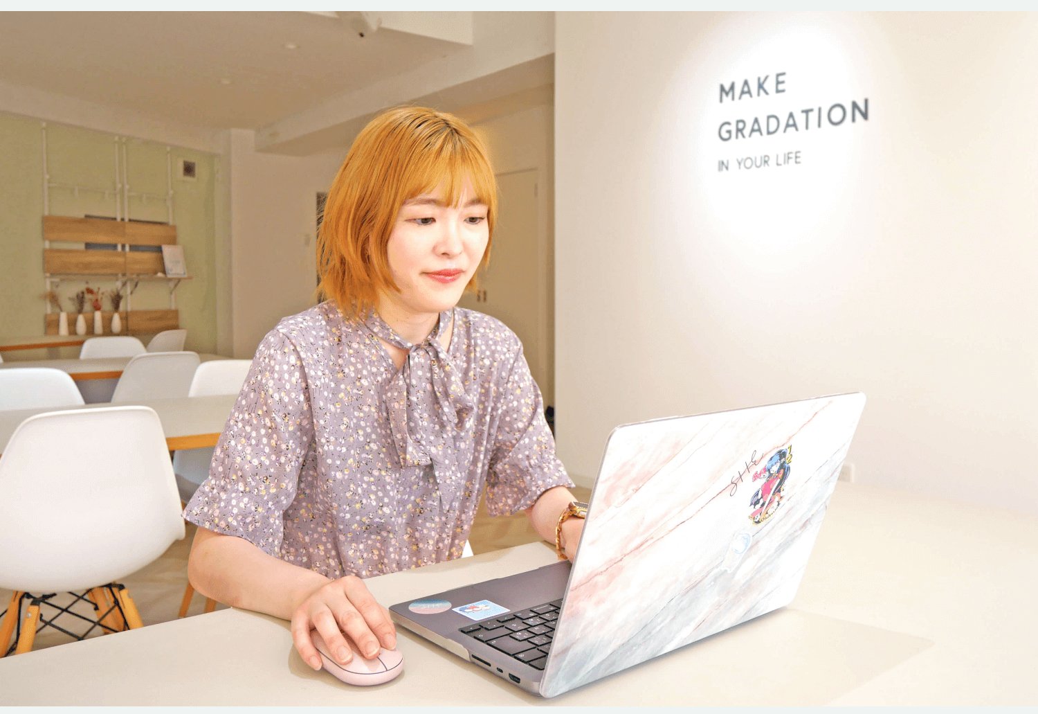 SHEのカフェスペースでノートPCに向かうmamiさん
