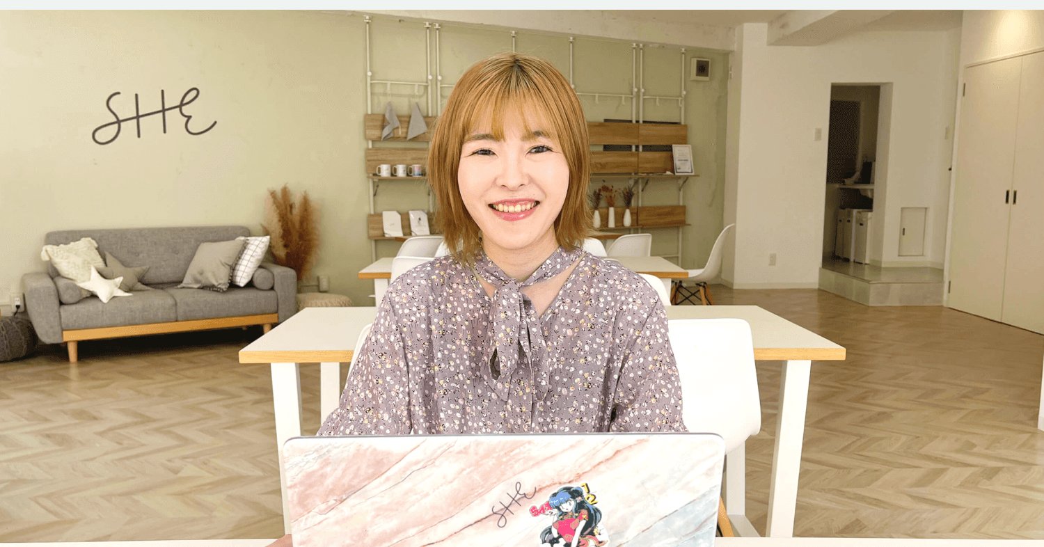 SHEのオフィスでノートPCに向かい微笑むmamiさん