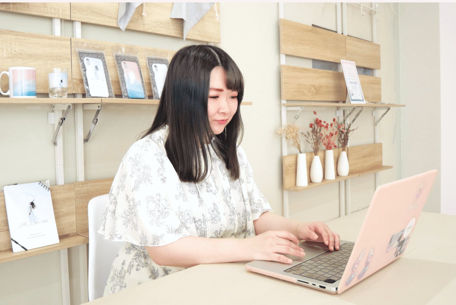 SHElikesの拠点でノートPCに向かい微笑むもかさん
