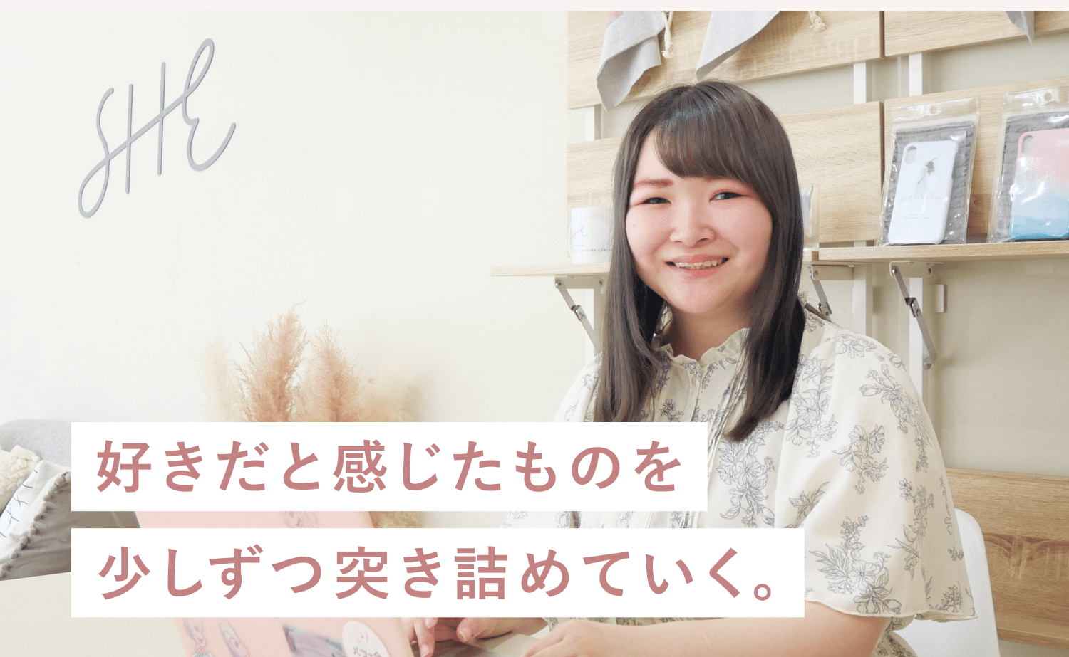 SHElikes拠点でノートPCに向かい微笑むもかさんの写真に「好きだと感じたものを少しずつ突き詰めていく。」という白いマーカー帯の一文が重なった合成グラフィック
