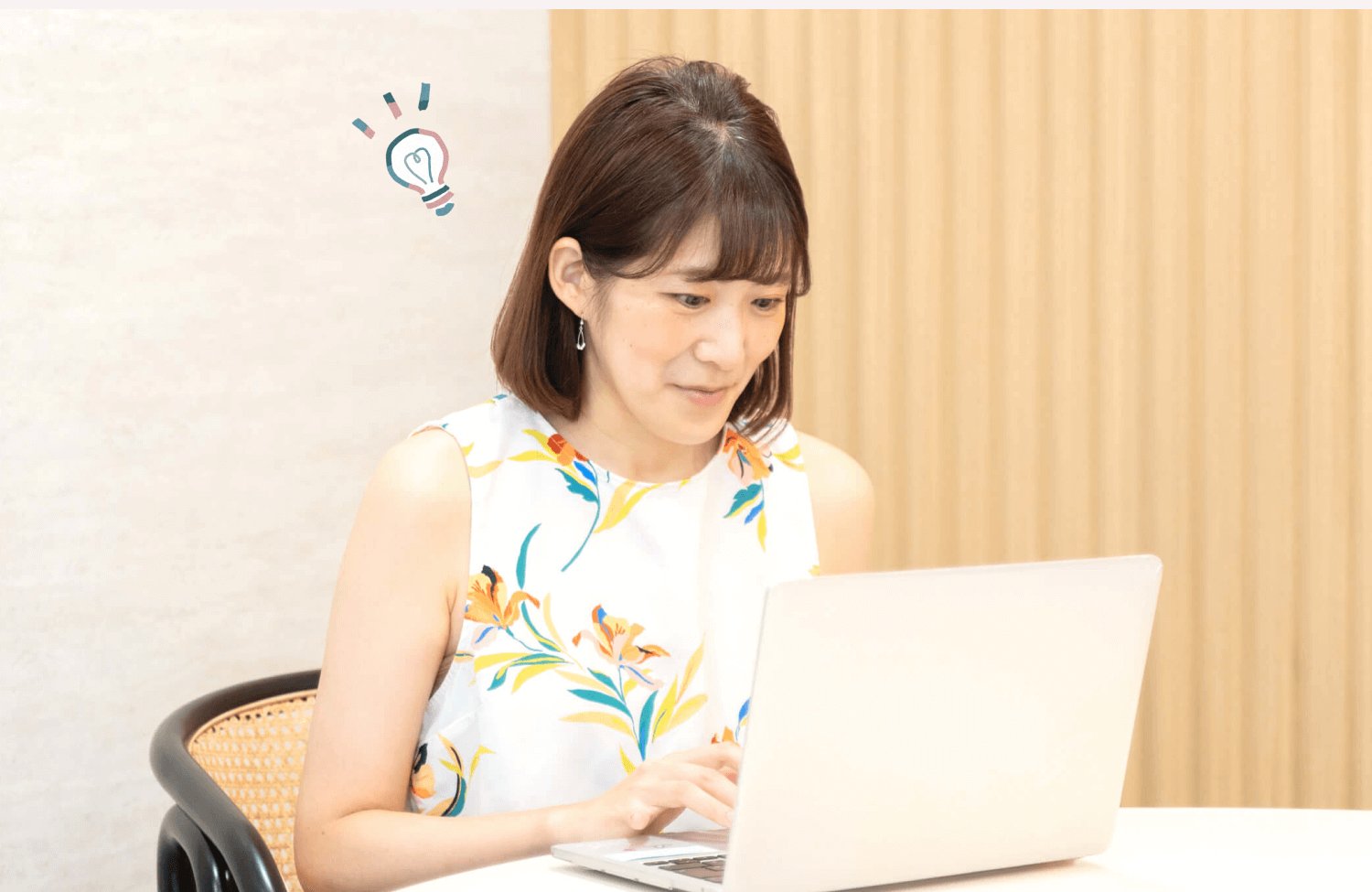 SHElikesの拠点でノートPCに向かい微笑むしょこまるさん