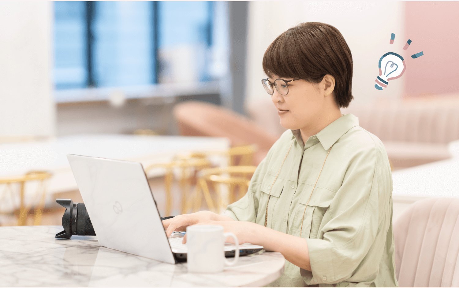 ワークスペースでノートPCに向かい微笑むnaokoさん