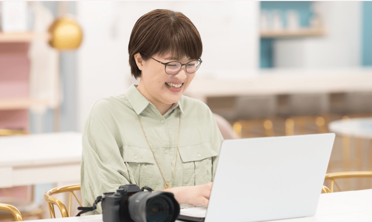 SHElikes拠点でノートPCに向かい微笑むnaokoさん