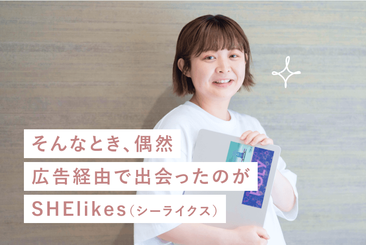 「そんなとき、偶然広告経由で出会ったのがSHElikes(シーライクス)」というメッセージが重なる、木目調の壁を背景に書類ファイルを抱えて微笑むあかりさんの写真
