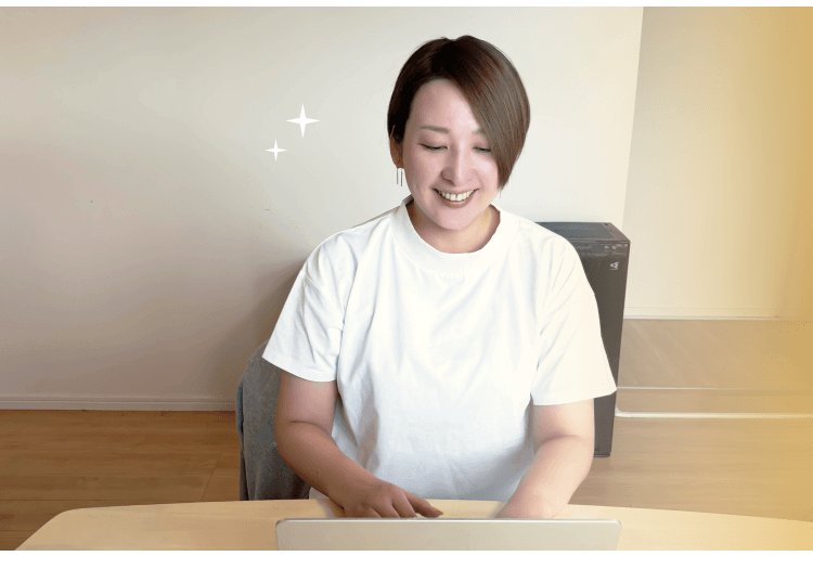白いTシャツで室内のテーブルに向かい、ノートPCに入力するなべりなさん